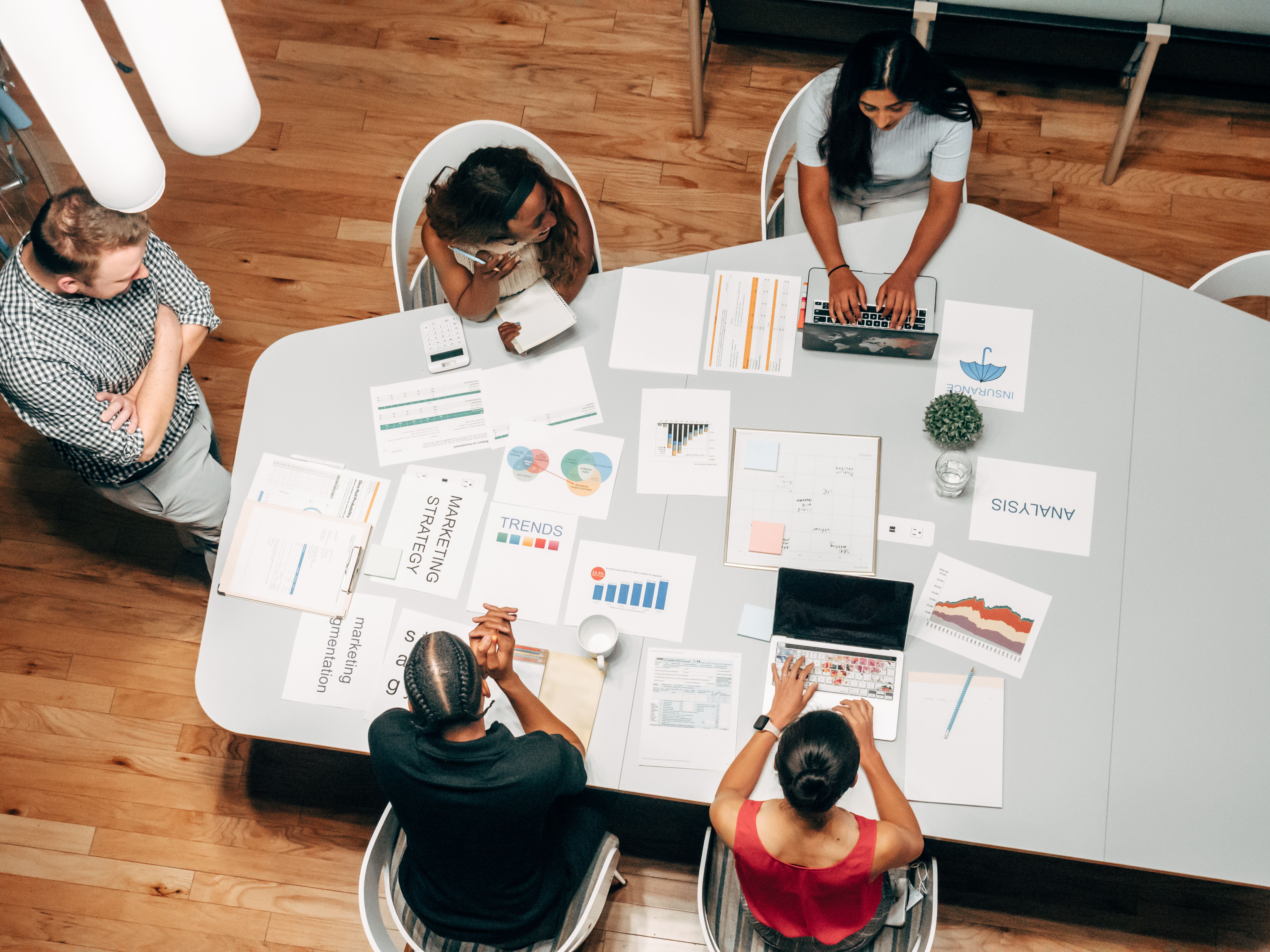 Team collaborating around a table, one of the industries ReIntellex automates