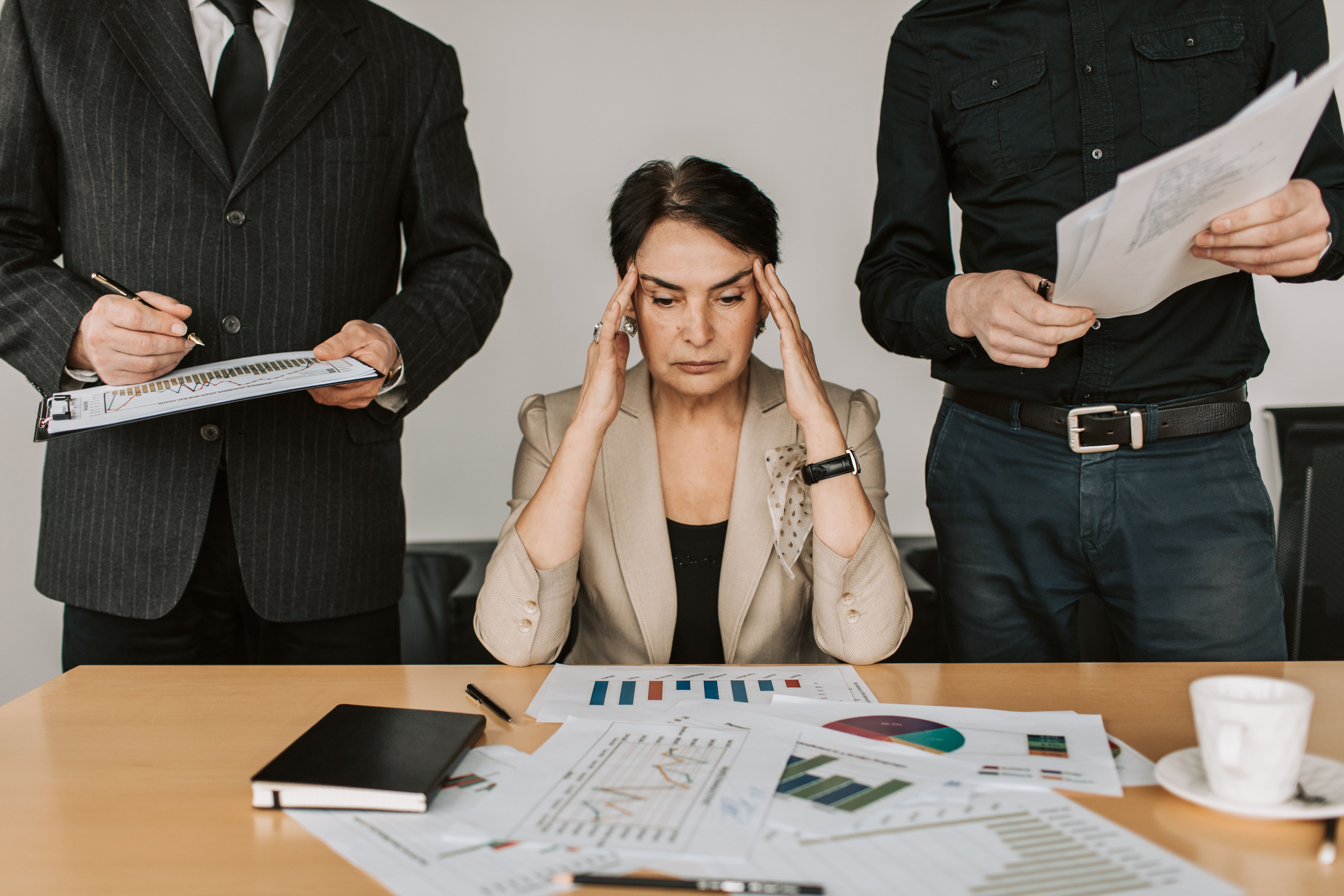 Overwhelmed small business owner buried in manual paperwork that AI automation can replace